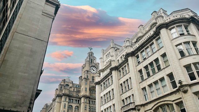 The Royal Liver Building clock tower under a pink evening sky.